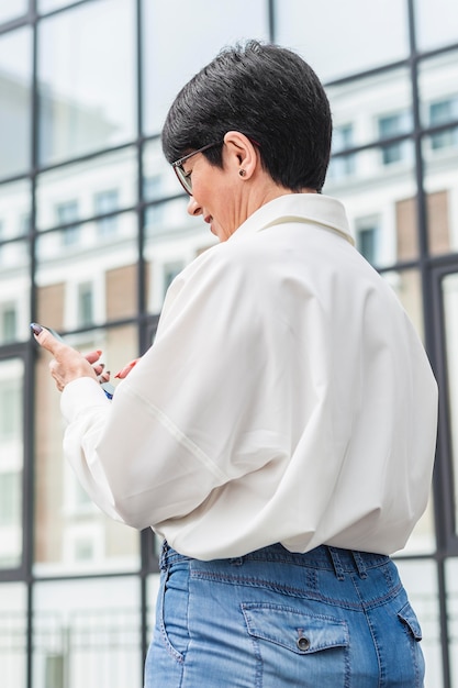 Gratis foto zakenvrouw met behulp van haar mobiele telefoon