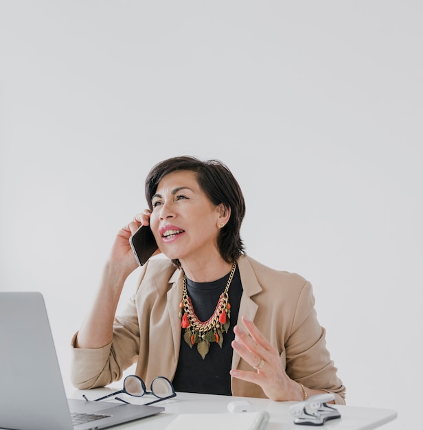 Gratis foto zakenvrouw met ketting praten aan de telefoon