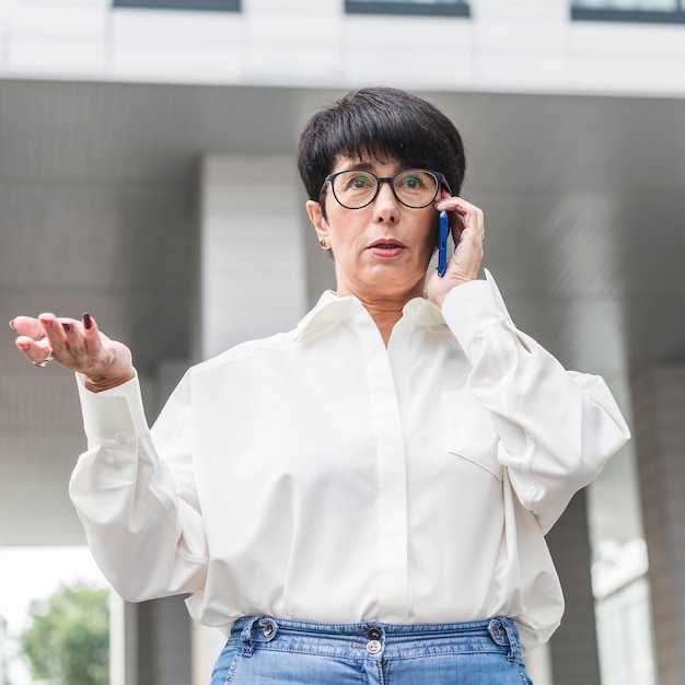 Zakenvrouw praten over haar lage mening van de telefoon