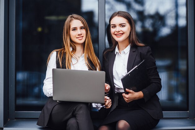 Zakenvrouw praten voor businessplan terwijl ze op laptop zit! Nabij kantorencentrum! Succesvol leven!