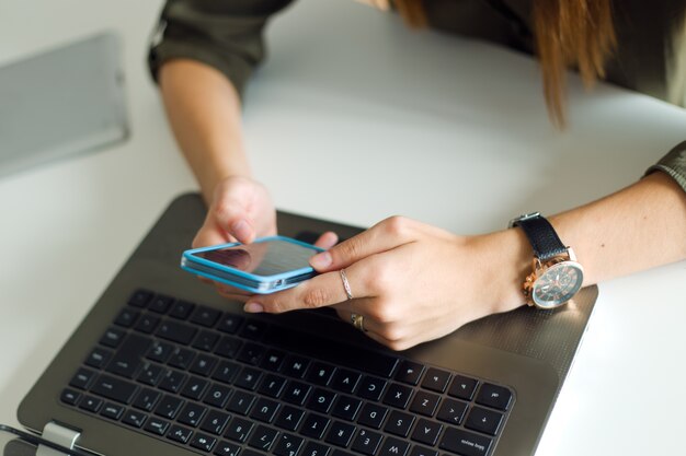 Zakenvrouw werken met mobiele telefoon in haar kantoor.