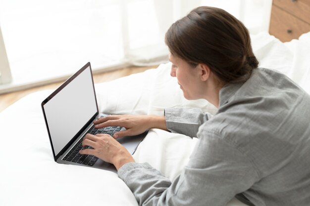 Zakenvrouw werkt vanuit huis in haar bed