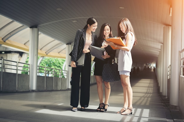 Zakenvrouwen bespreken over papierwerk samen tegen reling. Business mensen concept.