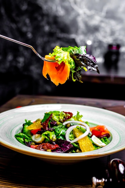 Zalm salade oranje ei kappertjes zongedroogde tomaat ui basilicum zijaanzicht