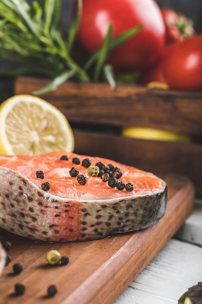 Zalm segmenten met tomaten en peper op een houten bord