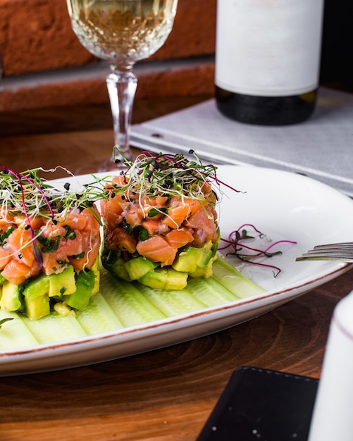 Gratis foto zalmsalade met avocado geserveerd met plakjes komkommer en groenten