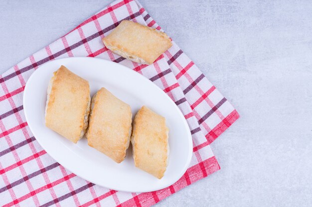 Zandkoekjes op een bord op een theedoek, op het marmer.