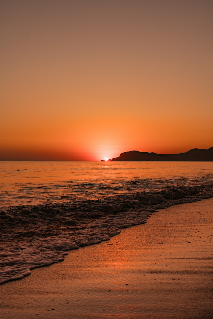 Gratis Foto zeegezicht met heldere hemel en golven op zonsondergang