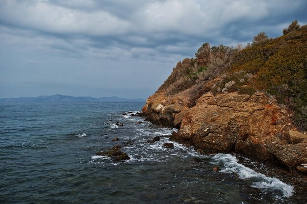 Zeegolf breekt op het landschap van strandrotsen Zeegolven beuken en spatten op rotsen bij Bodrum, Turkije