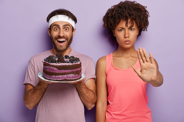 Gratis foto zeg nee tegen schadelijk eten! ernstige donkere vrouw toont stopgebaar