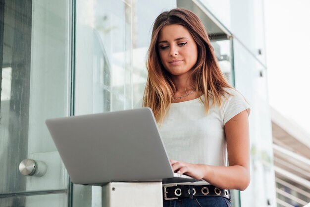 Zekere jonge vrouw het doorbladeren laptop