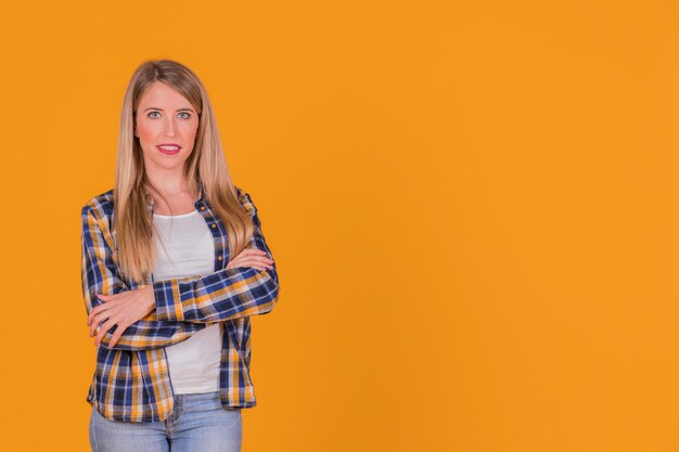 Zekere jonge vrouw met haar gekruiste arm het kijken aan camera