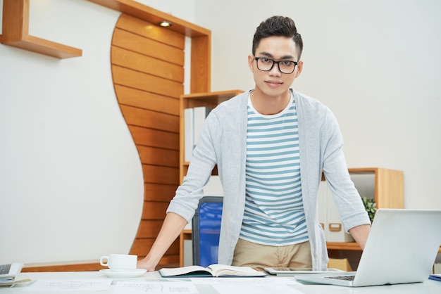 Gratis foto zekere jonge zakenman in bureau