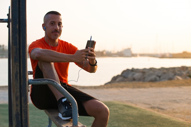 Zekere mid-adult man luisteren muziek van de telefoon