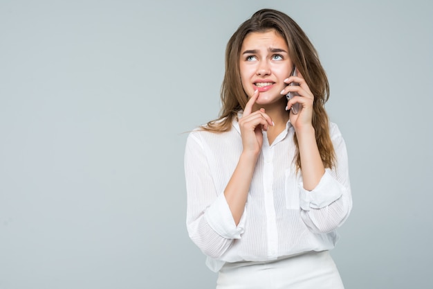 Zekere onderneemster die op de mobiele celtelefoon spreekt die op wit wordt geïsoleerd