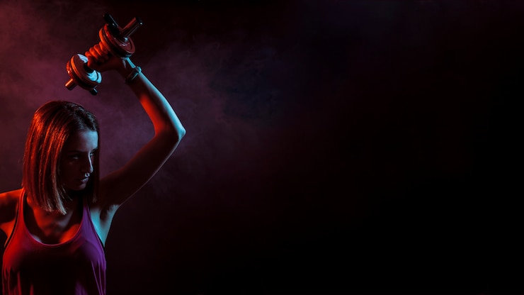 Gratis Foto zekere sportvrouw met domoor in dark