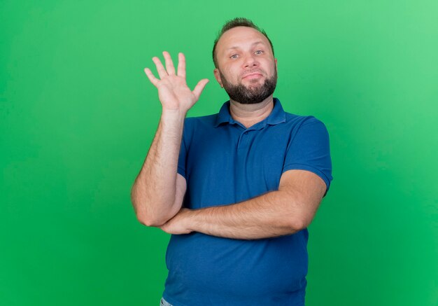 Zekere volwassen Slavische mens die vijf met hand toont die op groene muur met exemplaarruimte wordt geïsoleerd