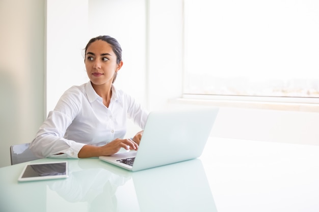 Zekere vrouwelijke adviseur die aan computer werkt