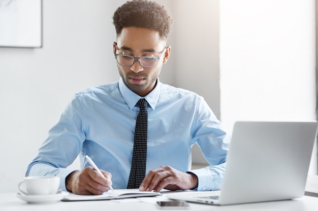 Zekere zakenman die aan zijn laptop werkt