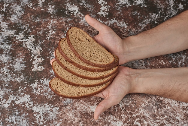 Gratis foto zelfgebakken brood in de hand van de kok.