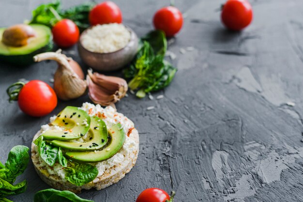 Zelfgemaakt ontbijt met cherrytomaatjes; knoflook; avocado en rauwe rijst op achtergrond