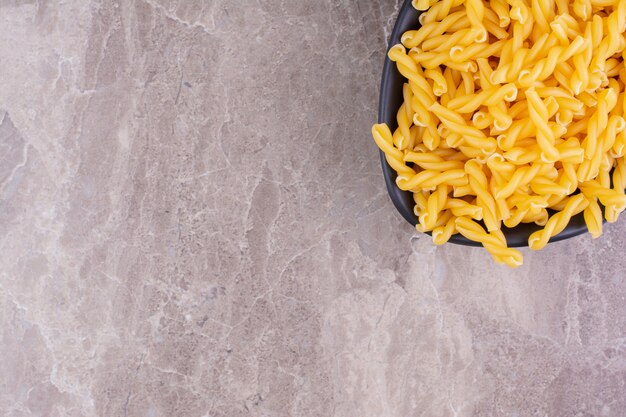 Zelfgemaakte biologische pasta's in een zwarte keramische plaat