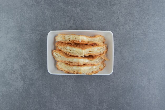 Zelfgemaakte gebakjes met kaas op witte plaat.