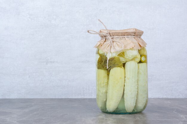 Zelfgemaakte gefermenteerde komkommers in glazen pot.