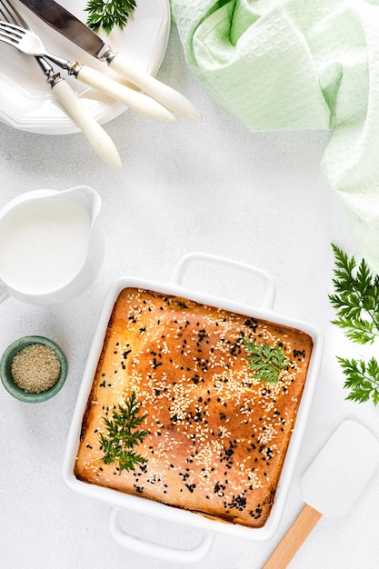 Zelfgemaakte gesloten taart met groenten op een witte betonnen ondergrond Ingrediënten voor een kool- en worteltaart op tafel