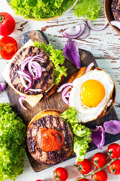 Zelfgemaakte hamburger maken. ingrediënten voor het koken op een houten tafel. Bovenaanzicht. Verticaal