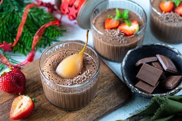 Zelfgemaakte heerlijke chocolademousse of panna cotta met bessen op een witte steen of houten ondergrond Feestelijk dessert