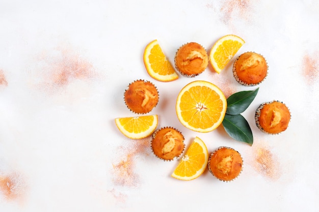 Gratis foto zelfgemaakte heerlijke oranje muffins met verse sinaasappels.