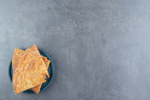 Zelfgemaakte verse driehoek gebakjes op blauw bord.