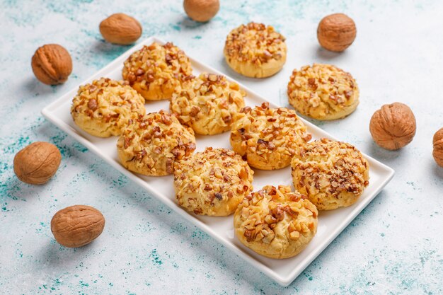 Zelfgemaakte walnoot cookies in witte plaat met walnoten op lichte tafel