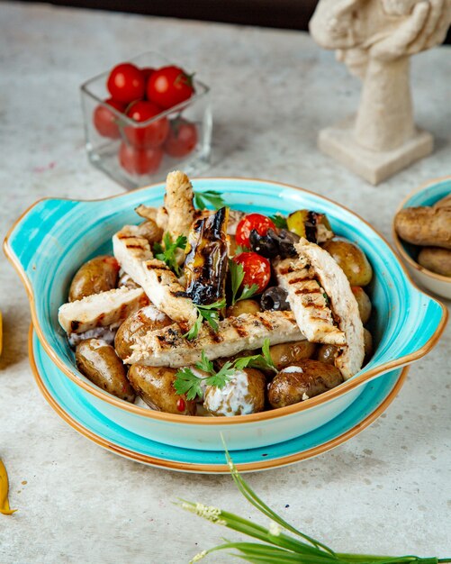 Zelfs gebakken kip en aardappelen met tomaten en paprika bovenaanzicht