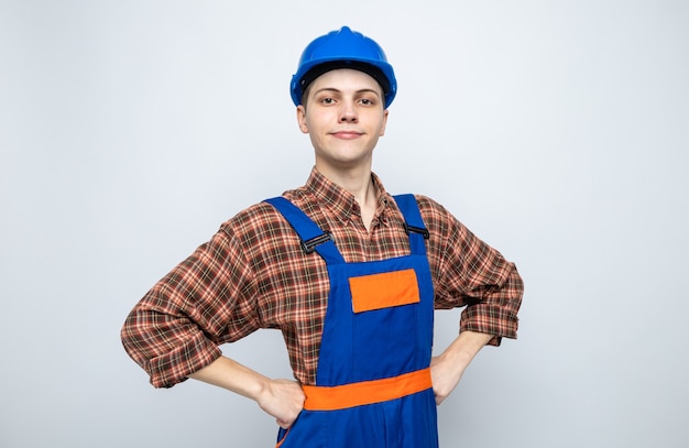 Gratis foto zelfverzekerd handen op de hippe jonge mannelijke bouwer die uniform draagt