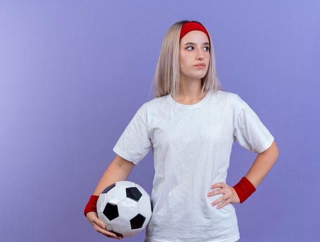 Zelfverzekerd jong Kaukasisch sportief meisje met steunen die hoofdband dragen