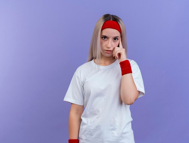 Zelfverzekerd jong Kaukasisch sportief meisje met steunen die hoofdband dragen