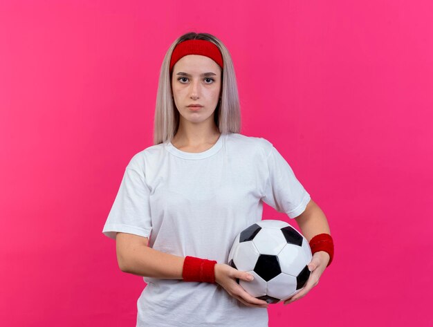 Zelfverzekerd jong Kaukasisch sportief meisje met steunen die hoofdband dragen