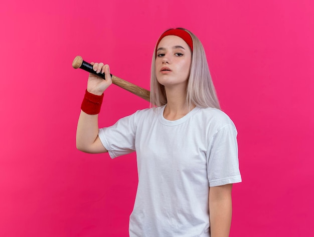 Zelfverzekerd jong Kaukasisch sportief meisje met steunen die hoofdband dragen