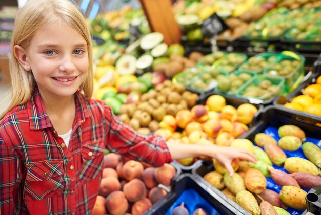 Zelfverzekerd meisje dat rijp fruit kiest