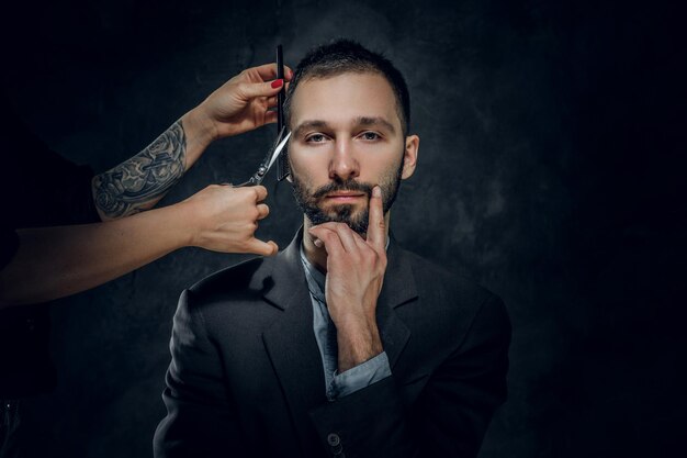 Zelfverzekerde elegante zakenman ontvangt een baardverzorging van een vrouw met mooie manicure.