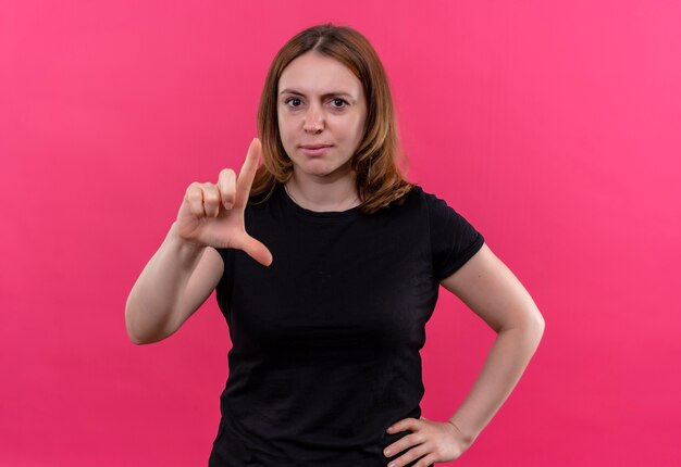 Zelfverzekerde jonge casual vrouw gebaren grootte met hand op taille op geïsoleerde roze ruimte