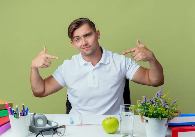 Zelfverzekerde jonge knappe mannelijke student zit aan bureau