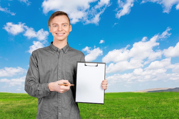 Zelfverzekerde jonge man in shirt die aantekeningen maakt in zijn notitieblok