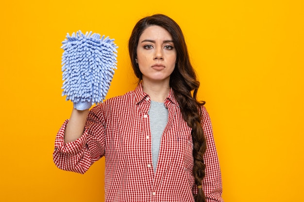 Zelfverzekerde, mooie blanke schonere vrouw die microfiber schoonmaakhandschoen vasthoudt en kijkt