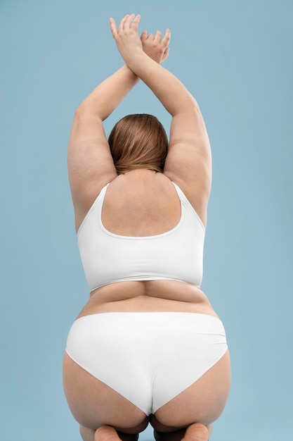 Zelfverzekerde oversized vrouw poseren in witte lingerie