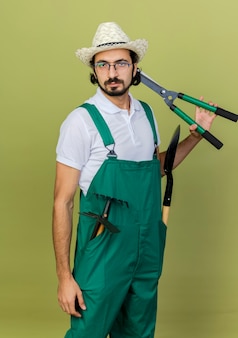 Zelfverzekerde tuinman met een optische bril die tuinhoeden draagt met tuingereedschap