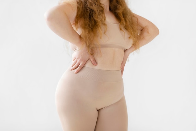 Gratis foto zelfverzekerde vrouw die zich voordeed terwijl ze een bodyshaper draagt