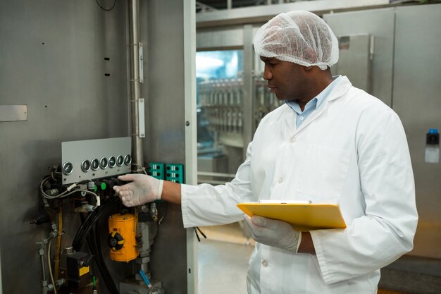 Zelfverzekerde werknemer werkende machine in sapfabriek